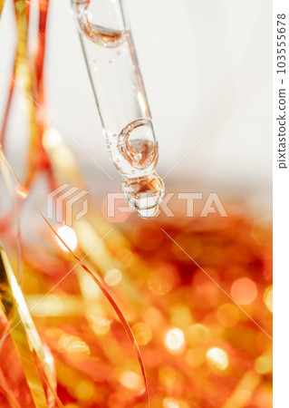 Pipette with gel on the background of tinsel. Pipette with gel on the background of tinsel. 103555678