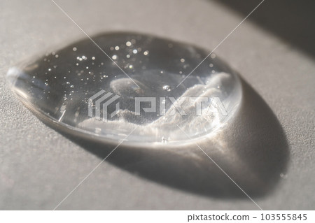 The texture of the serum or oil on an emerald background. 103555845