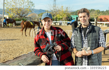 Married couple owners of stable against the backdrop of corral for walking horses Married couple owners of stable against the backdrop of corral for walking horses 103556223