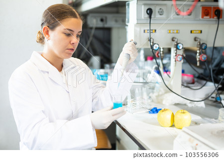 Clever female researcher in white coat mixing reagents in test tube with lab pipette while working in laboratory Clever female researcher in white coat mixing reagents in test tube with lab pipette while working in laboratory 103556306
