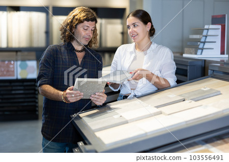 Married couple choosing ceramic tiles for new home furnishing at hardware store Married couple choosing ceramic tiles for new home furnishing at hardware store 103556491
