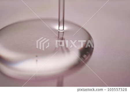 A juicy drop of gel on a purple background. 103557328