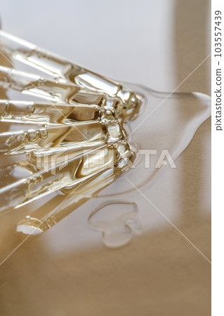 Pipettes with oil or serum on a golden background. 103557439