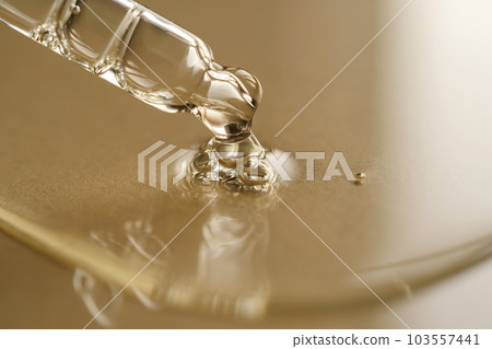 Pipettes with oil or serum on a golden background. 103557441