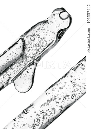 Transparent pipette with cosmetics on a light background. Transparent pipette with cosmetics on a light background. 103557442