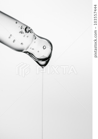 Transparent pipette with cosmetics on a white isolated background. Transparent pipette with cosmetics on a white isolated background. 103557444