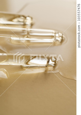 Pipettes with oil or serum on a golden background. Pipettes with oil or serum on a golden background. 103557476