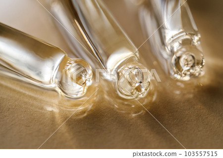 Pipettes with oil or serum on a golden background. Pipettes with oil or serum on a golden background. 103557515