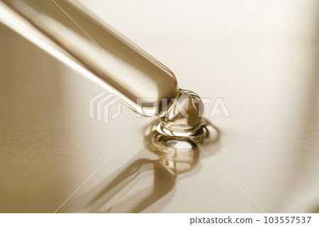 Pipettes with oil or serum on a golden background. 103557537
