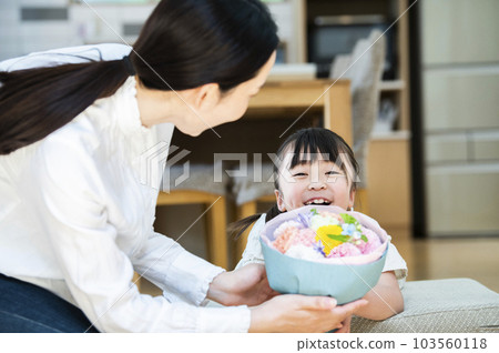 girl giving a bouquet to her mother 103560118