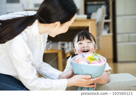 girl giving a bouquet to her mother girl giving a bouquet to her mother 103560121