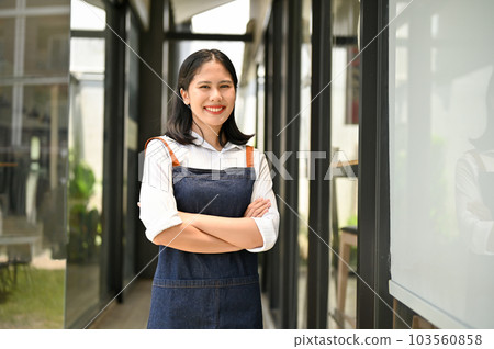 Successful Asian female restaurant or coffee shop owner stands in front of the entrance door Successful Asian female restaurant or coffee shop owner stands in front of the entrance door 103560858