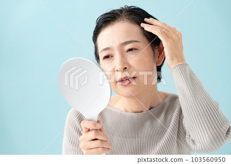Worried woman looking at the mirror hair care beauty 103560950