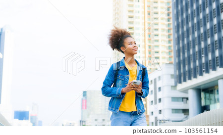 Black young woman, using smart phone and smile with walking in the city outdoor Black young woman, using smart phone and smile with walking in the city outdoor 103561154