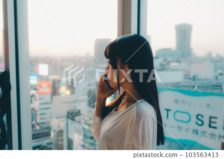 站在城市夕陽下的年輕女子 103563413