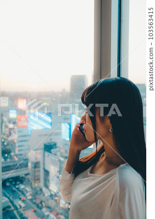 站在城市夕陽下的年輕女子 103563415