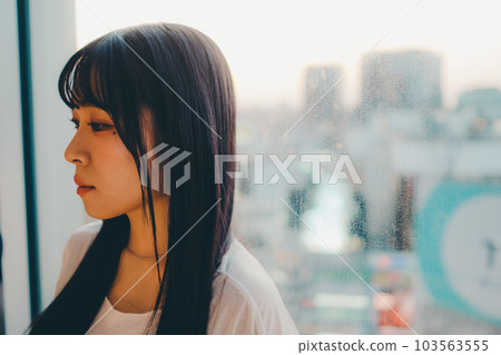 Young woman standing in the city sunset 103563555