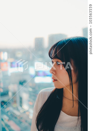站在城市夕陽下的年輕女子 103563559