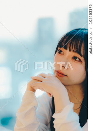 Young woman standing in the city sunset 103563576