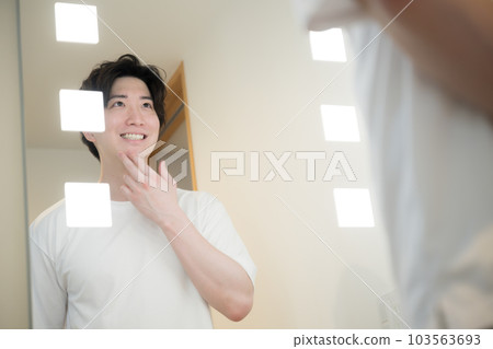 對著鏡子檢查鬍鬚和皮膚護理的男人 對著鏡子檢查鬍鬚和皮膚護理的男人 103563693