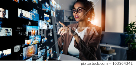 A woman looking at a PC in the office and a video content image A woman looking at a PC in the office and a video content image 103564341