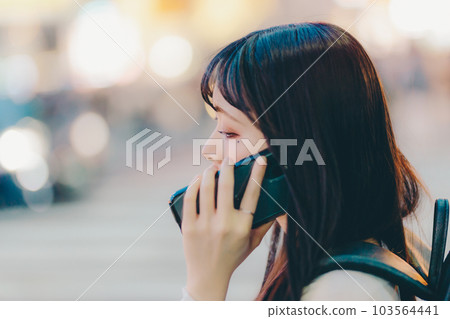 A young woman touching a smartphone A young woman touching a smartphone 103564441