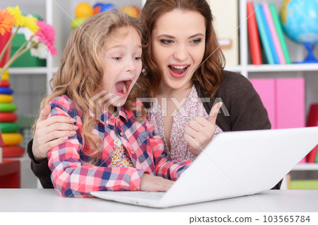 happy mother and daughter using laptop together 103565784