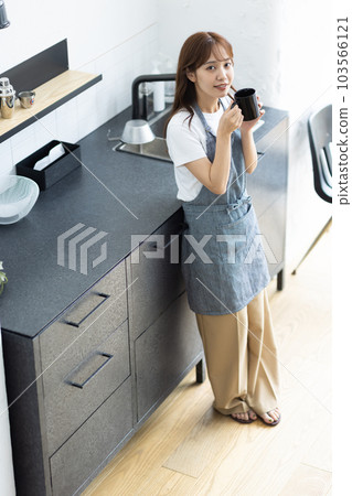 一名婦女飲用的咖啡在廚房裡 103566121