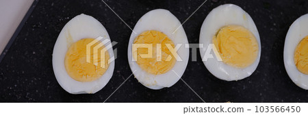 Hard boiled eggs cut in half on black background 103566450
