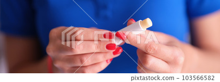 Tube with hygienic lipstick in female hand 103566582