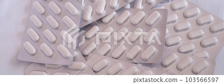 White medical round pills in metal blister 103566597