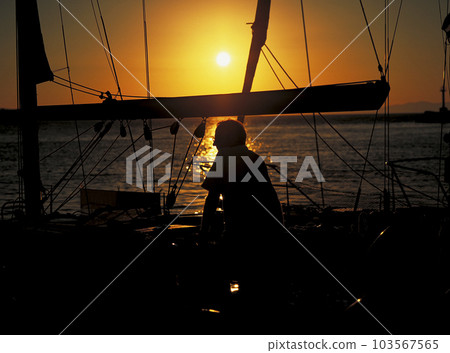 Silhouette of a cruiser yacht crew at sunset in the Aegean sea Silhouette of a cruiser yacht crew at sunset in the Aegean sea 103567565