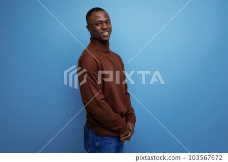 shy young american man laughing embarrassedly against studio background with copy space 103567672