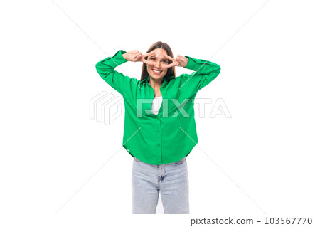 well-groomed slender brunette woman with long hair dressed in a casual green shirt makes faces well-groomed slender brunette woman with long hair dressed in a casual green shirt makes faces 103567770