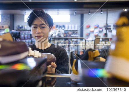 man looking at shoes in clothing store man looking at shoes in clothing store 103567840