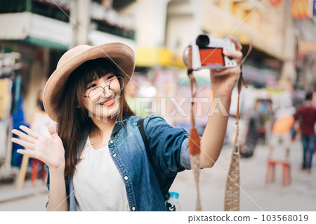 Young asian woman backpack travel in city with camera 103568019