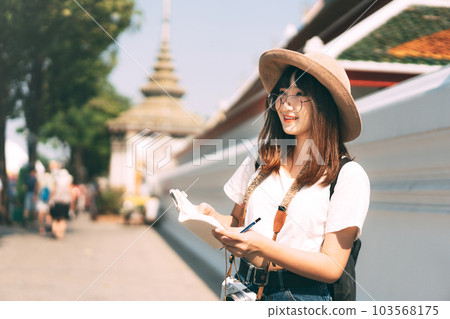 Young adult asian travel woman at landmark temple outdoor on day. Bangkok, Thailand. Young adult asian travel woman at landmark temple outdoor on day. Bangkok, Thailand. 103568175