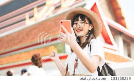 Young adult tourist asian woman using smart phone for listen music application. Young adult tourist asian woman using smart phone for listen music application. 103568229