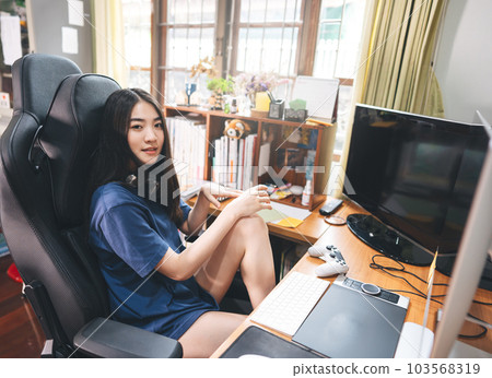 Portrait young adult artist freelancer wear headset asian woman in workplace space with window light on day. Portrait young adult artist freelancer wear headset asian woman in workplace space with window light on day. 103568319
