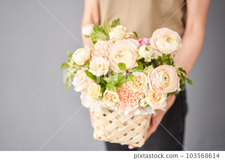 Flower arrangement in Wicker basket. Beautiful bouquet of mixed flowers in woman hand. Floral shop concept . Handsome fresh bouquet. Flowers delivery Flower arrangement in Wicker basket. Beautiful bouquet of mixed flowers in woman hand. Floral shop concept . Handsome fresh bouquet. Flowers delivery 103568614