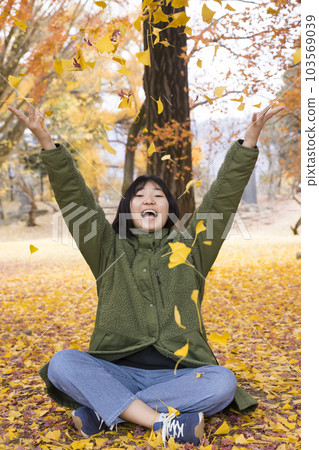 Girl throwing a lot of fallen leaves in the park Autumn image Girl throwing a lot of fallen leaves in the park Autumn image 103569039