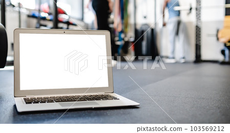 Netbook mock up with white screen placed on floor in gym 103569212