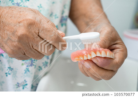 Asian elderly woman patient holding to use denture, healthy strong medical concept. Asian elderly woman patient holding to use denture, healthy strong medical concept. 103570077