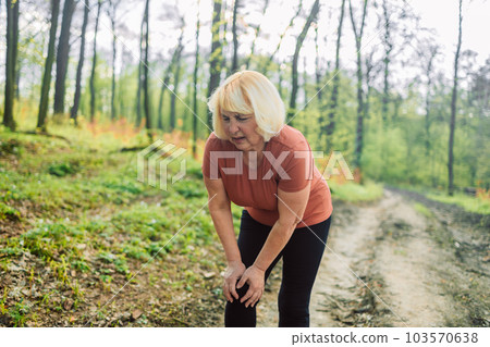 50s 60s fitness woman runner feel pain on knee. Outdoor exercise activities concept 103570638