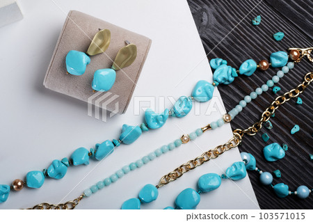 author collection jewelry with azure gemstones, pearls and chain demonstrated at white  background.  fashion and jewelry concept. flat lay 103571015