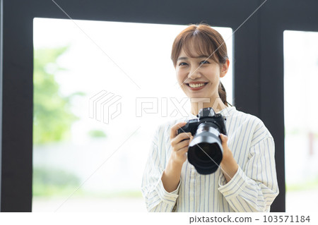 smiling woman holding a camera smiling woman holding a camera 103571184