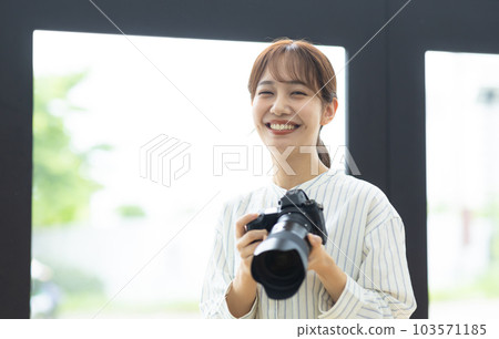 smiling woman holding a camera smiling woman holding a camera 103571185