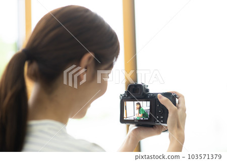 Female photographer shooting a model Female photographer shooting a model 103571379
