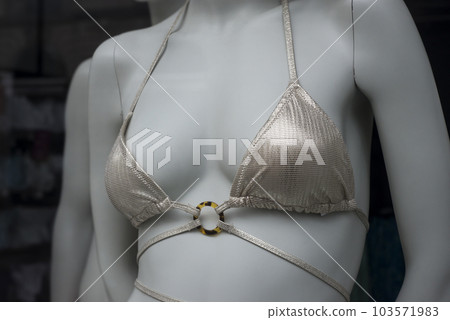 closeup of golden bikini on mannequin in fashion store showroom for women closeup of golden bikini on mannequin in fashion store showroom for women 103571983
