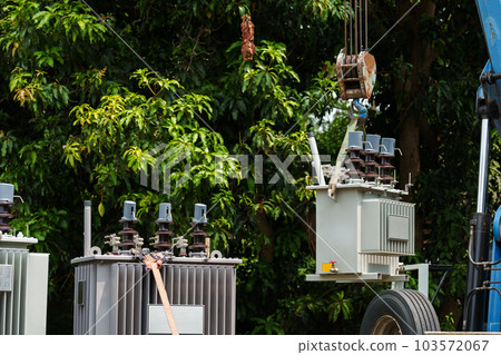 Crane hook lifts up distribution transformer 103572067